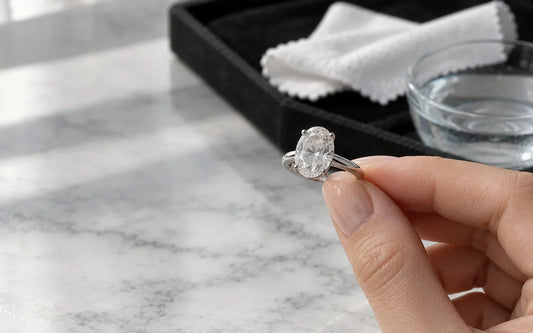 Woman inspecting a moissanite ring with surface residue in soft window light